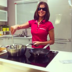 a woman in a red shirt is cooking some food on the stove top with a spatula