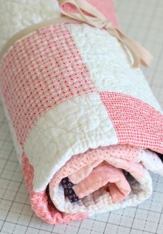 a pink and white blanket folded on top of a cutting board