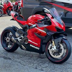 a red and black motorcycle parked next to other motorcycles