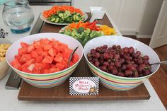 three bowls filled with fruit on top of a wooden tray next to a bowl of grapes and watermelon