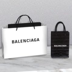 two black and white shopping bags sitting on top of a marble counter next to each other