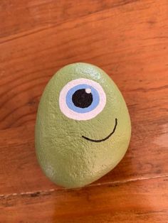 a green rock with an eye painted on it