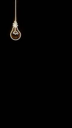 a light bulb hanging from a wire in the dark