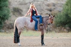 a woman riding on the back of a brown horse