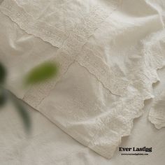 an old white linen with lace on it and a green plant in the foreground