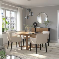 a dining room table with chairs and a laptop computer on it, in front of a window