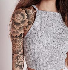 a woman with tattoos on her arm and shoulder