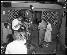 an old black and white photo of some people in a room with cameras on the floor