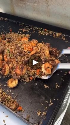 a pan filled with food sitting on top of a stove next to a person holding a spat