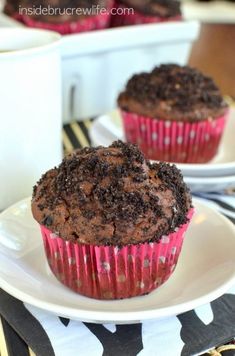 two chocolate muffins sitting on top of a white plate