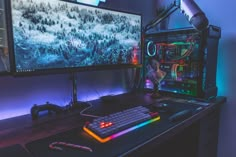 a computer monitor and keyboard sitting on top of a desk next to a large screen