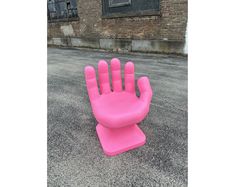 a pink hand shaped object sitting on the ground