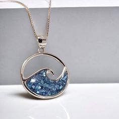 Capture the beauty of the ocean with our 925 Sterling Silver Ocean Wave Necklace. Crafted with sparkling blue accents encased in resin, this necklace is the perfect Hawaiian beach gift and summer jewelry piece. Each pendant is made with high-quality 925 sterling silver for lasting elegance. Dive into style and make a statement with this stunning necklace! THIS STERLING SILVER WAVE NECKLACE FEATURES        -  Solid 925 sterling silver          - Comes ready to wear on a solid 925 sterling silver Marine Jewelry, Summer Jewelry Beach, Wax Carving Jewelry, Fused Jewelry, Carving Jewelry, Wave Jewelry, Mothers Day Jewelry, Blue Pendant Necklace, Elven Jewelry