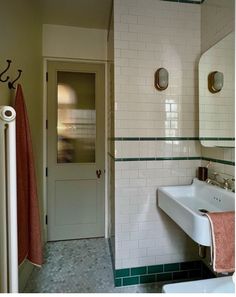 a white sink sitting under a bathroom mirror next to a doorway with two mirrors above it