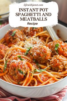 spaghetti and meatballs in a white bowl with parmesan cheese on the side