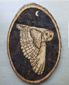 an owl is flying through the night sky on a wood slice with swirls and stars