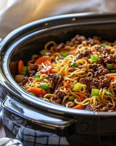 a slow cooker filled with noodles and meat