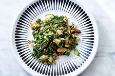 a white bowl filled with chopped vegetables on top of a marble countertop next to a fork