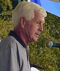 an older man standing in front of a microphone