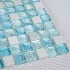 blue and white glass mosaic tiles on a table top, with one square in the middle