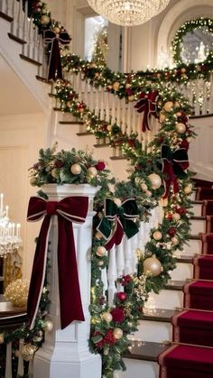 stairs decorated for christmas with garlands and ornaments on the bannister rail, chandelier and wreath