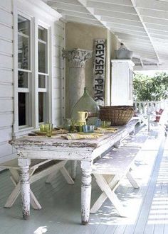 a white table sitting on top of a wooden porch