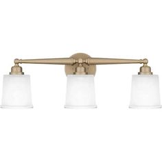 three light bathroom fixture in an antique brass finish with frosted glass shades on the sides