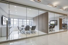 an empty conference room with glass walls and chairs