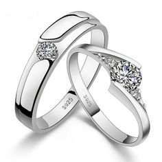 two white gold wedding rings with diamonds on each side and one diamond in the middle