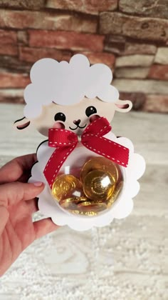 a hand holding a small ornament with a sheep on it