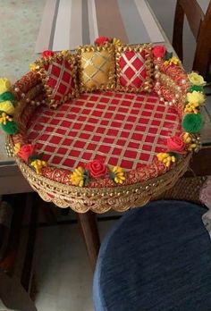 a red and gold tray sitting on top of a table next to a blue chair