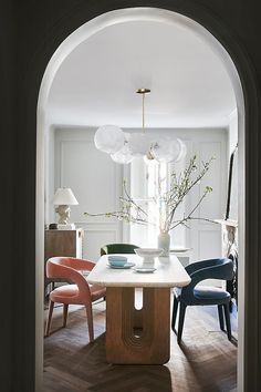 an archway leading to a dining room with chairs and a table in front of it