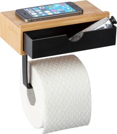 a cell phone is sitting on top of a shelf with a roll of toilet paper