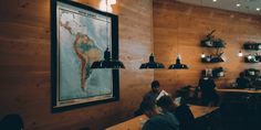 people sitting at tables in a restaurant with wooden walls and wood paneling on the wall