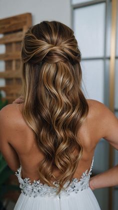 the back of a woman's head with long, wavy hair in her wedding dress