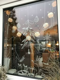 the window is decorated with christmas decorations and ornaments hanging from it's glass sill