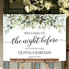 a welcome sign with white flowers hanging from it's front door and the words, welcome to the night before celebrating