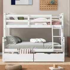 a white bunk bed sitting next to a wooden table with two pillows on top of it