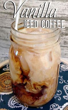 vanilla iced coffee in a mason jar on a tray with the words vanilla iced coffee