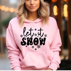 a woman wearing a pink hoodie that says let it snow