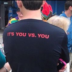 a man in a black shirt that says it's you vs you on his back