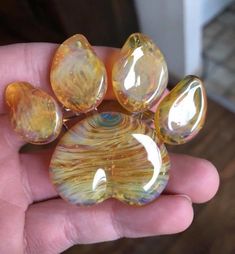 a hand holding some glass beads in it's left hand and the top one is yellow