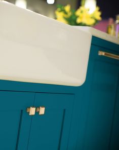 a white sink sitting on top of a blue cabinet