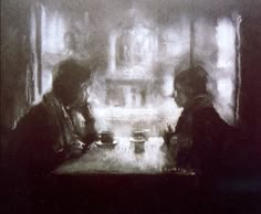 two people sitting at a table in front of a window with the light shining on them