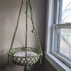 a green hanging basket next to a window