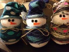 three knitted snowmen sitting next to each other