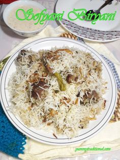 a white plate topped with rice and meat