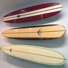 three surfboards are hanging on the wall