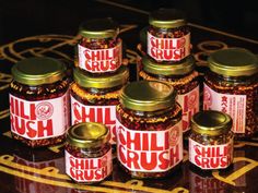 seven jars of chili crush sitting on top of a table