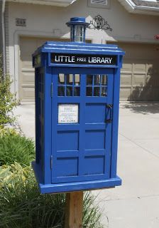 a blue phone booth sitting in front of a house